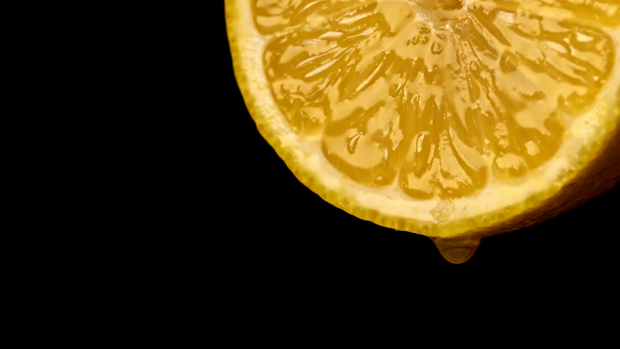 Saftige Scheibe gelber Zitrone mit einem Safttropfen.