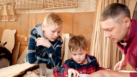 familia, carpintería, madera y concepto de la gente. el padre enseña a su hijo carpentería.