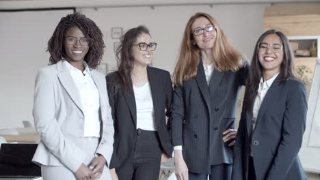 mujeres de negocios alegres sonriendo a la cámara