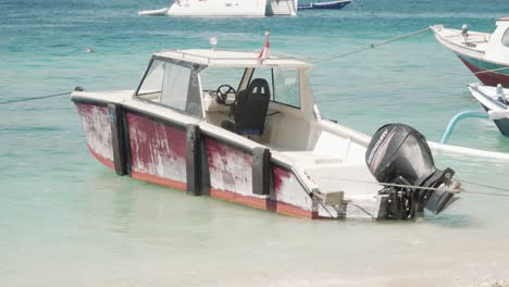 Kleines-Schiff-Am-Ufer-Eines-Sandstrandes-Mit-Kristallklarem-Wasser