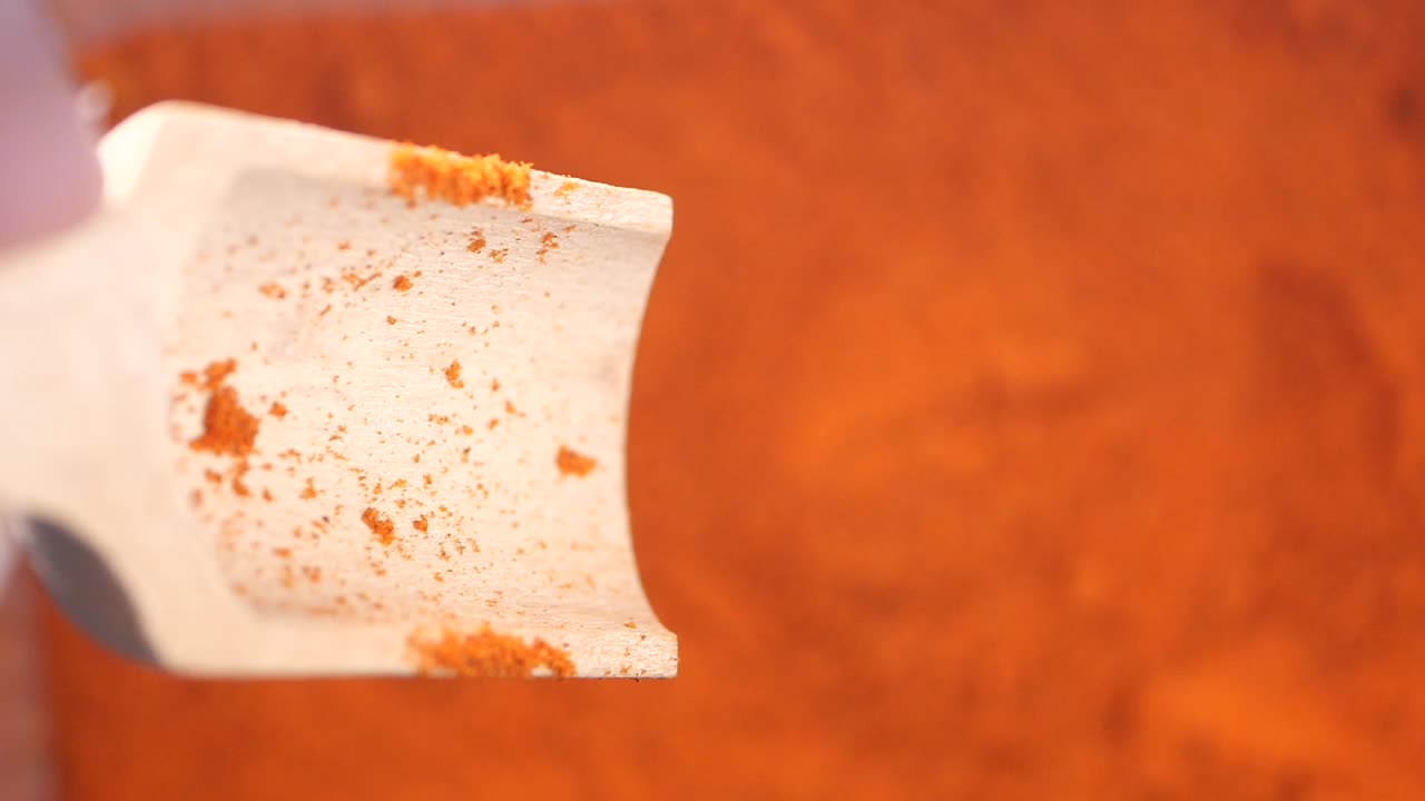 Wooden Spoon Scooping Red Chili Powder