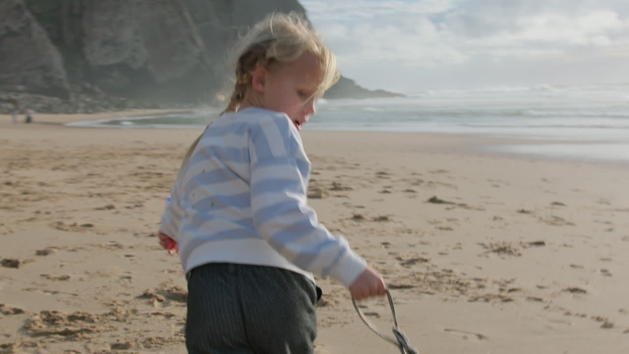 해변에서 달리는 행복한 유아 소녀