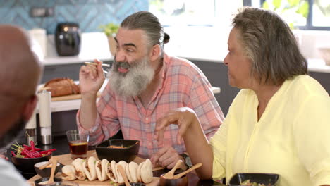 eating asian cuisine, senior friends enjoying meal and conversation at dining table