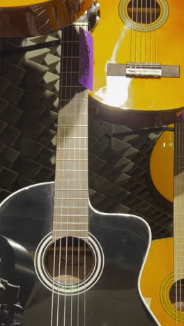 many colorful classical guitars hang on the wall in the shop.