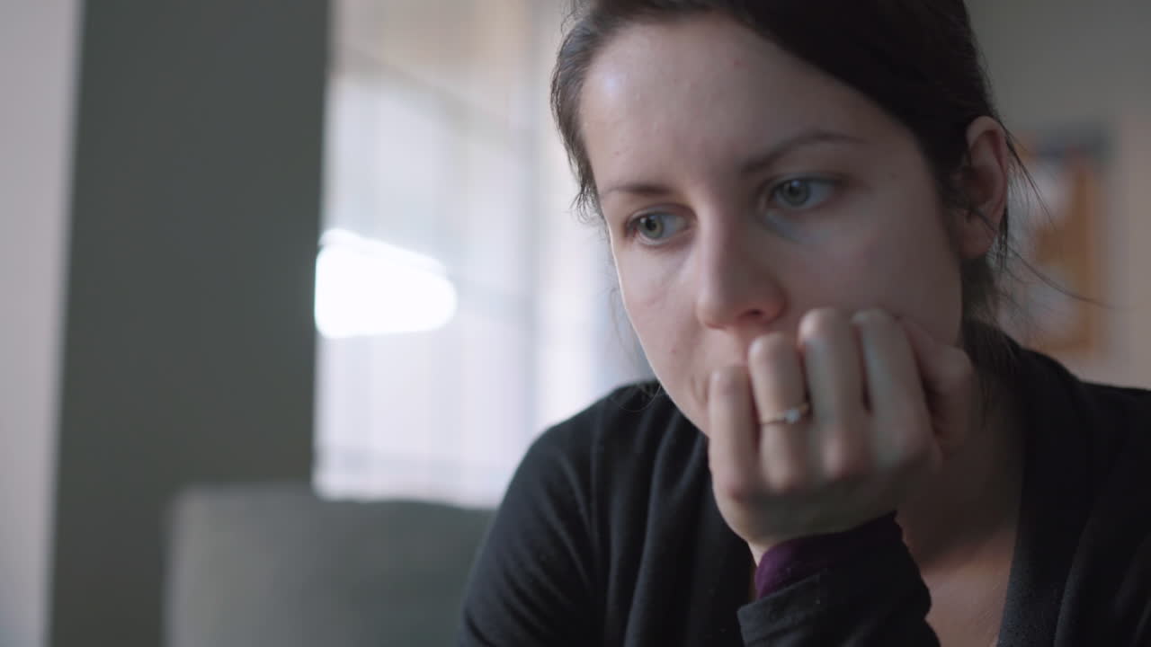 niña usando una computadora portátil mientras ve la televisión en la sala de estar