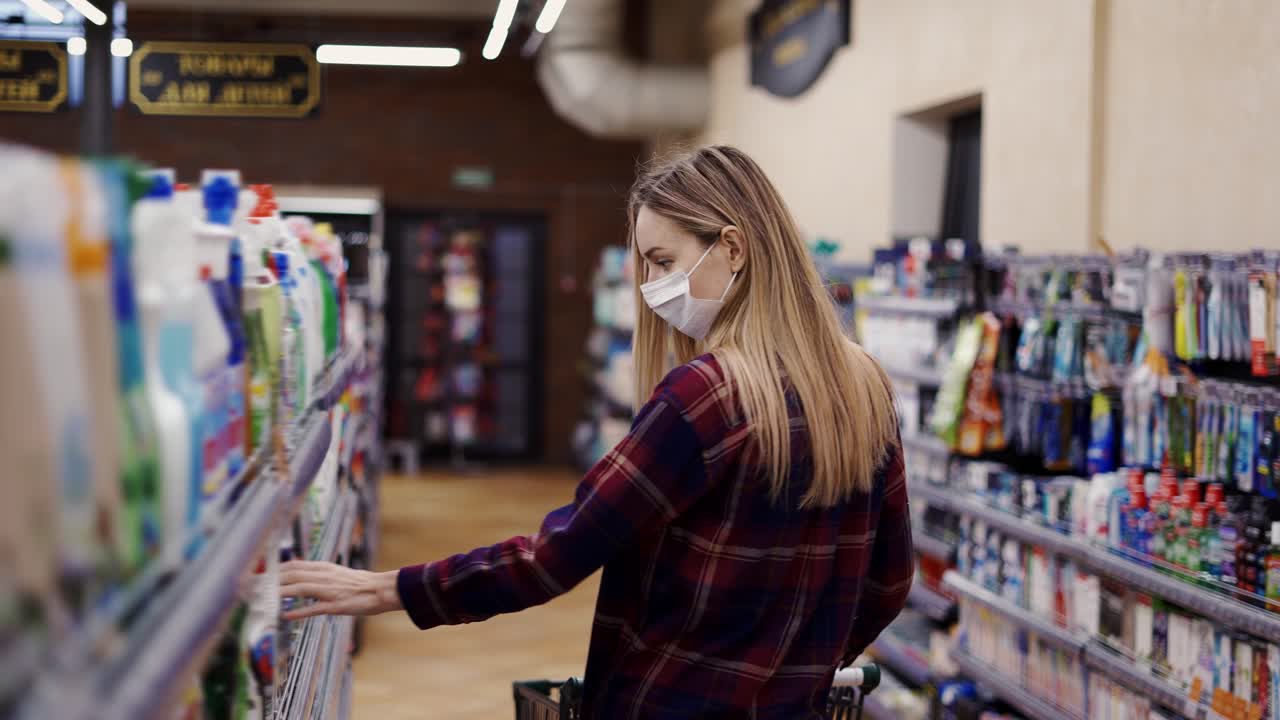 mujer eligiendo detergente en una tienda de artículos para el hogar
