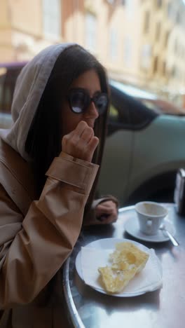 woman having coffee and pastry outdoors