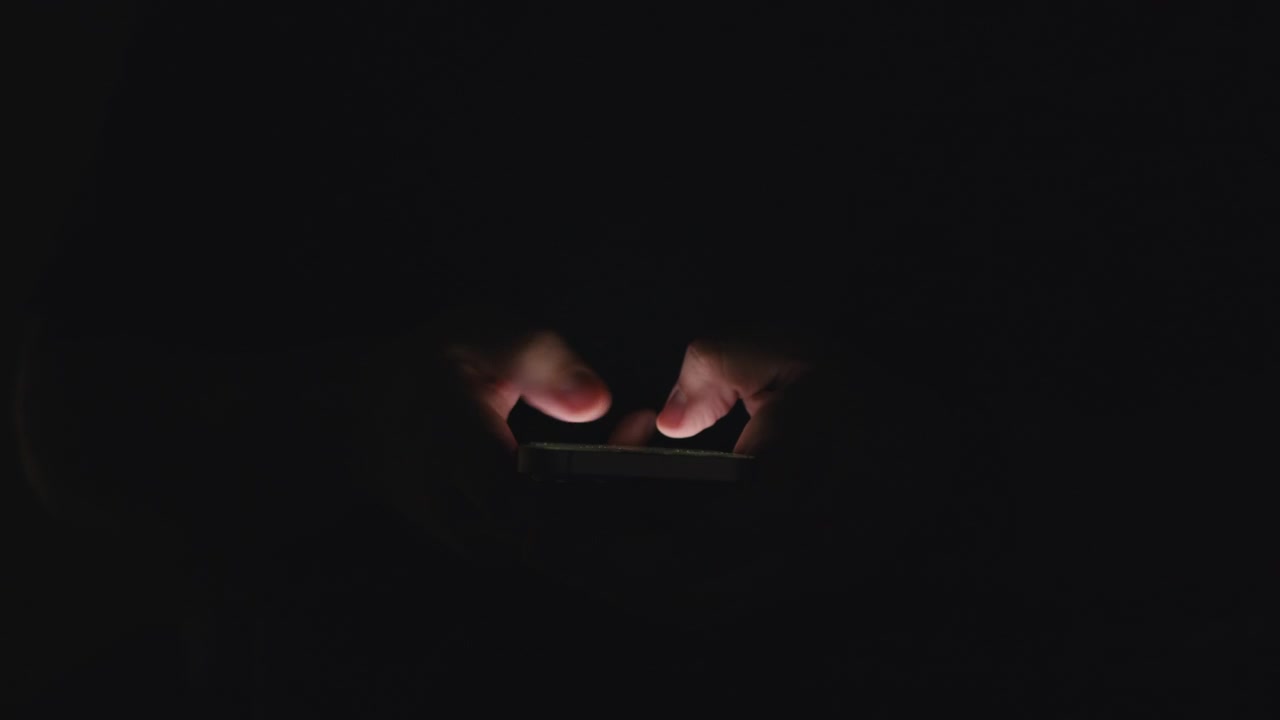 Persona che utilizza lo smartphone di notte