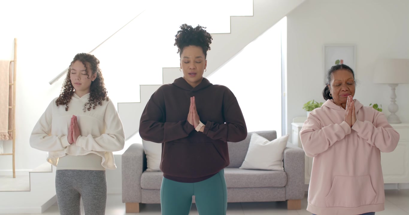 African American senior and youth women praying, breathing at home by couch as center woman guiding