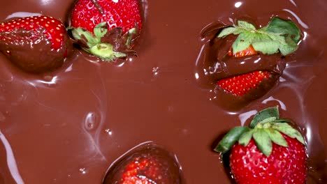 strawberries being dipped in melted chocolate