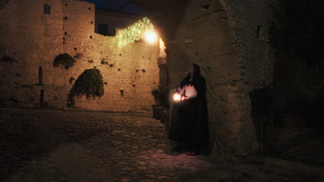 mysterious woman waits under an arch in the city with lantern