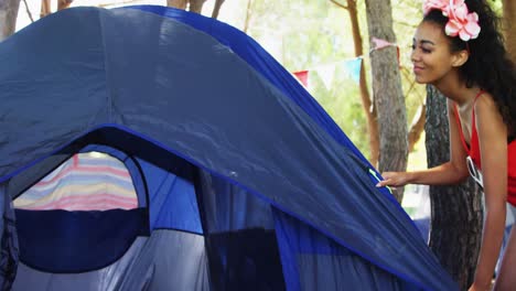 Couple-giving-high-five-while-setting-up-tent-in-park-4k