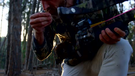 man aiming with compound bow in the forest 4k