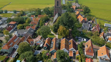 aerial above typical dutch village houses at waterfront tilt up to church