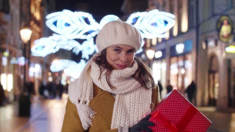 mujer sonriente sosteniendo un gran regalo