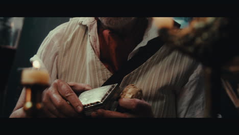 an old pirate eats and drinks and smokes a pipe inside the sailing ship cabin