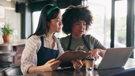 two women business partners discussing work in a cafe