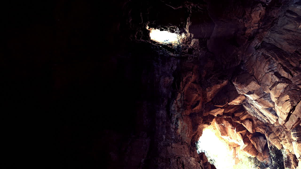 Cave with natural light openings illuminating the rocky interior