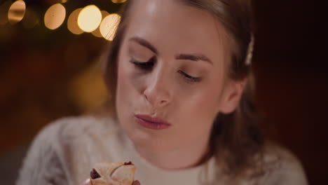 Young-Woman-Eating-Sweet-Cake-During-Christmas