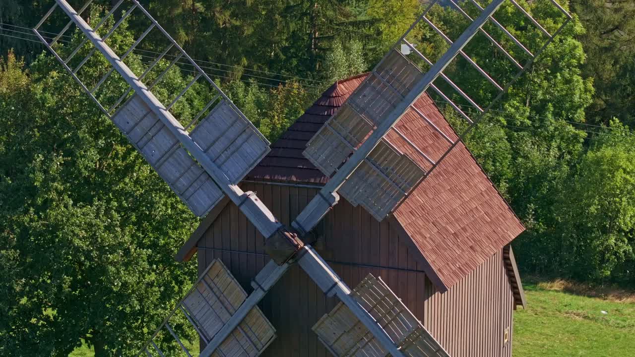 Aerial shot of a countryside windmill glowing in golden sunlight