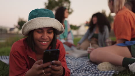 Picnic,-phone-and-woman-in-park-with-friends