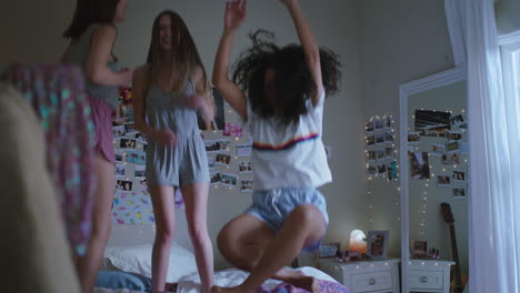 happy teenage girls jumping on bed at home best friends celebrating together enjoying vacation weekend