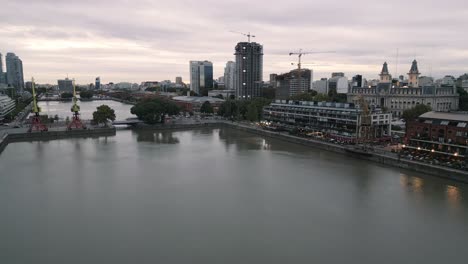 paisaje aéreo de la ciudad argentina de buenos aires en puerto madero, microcentro durante la puesta de sol con puerto comercial y grúa