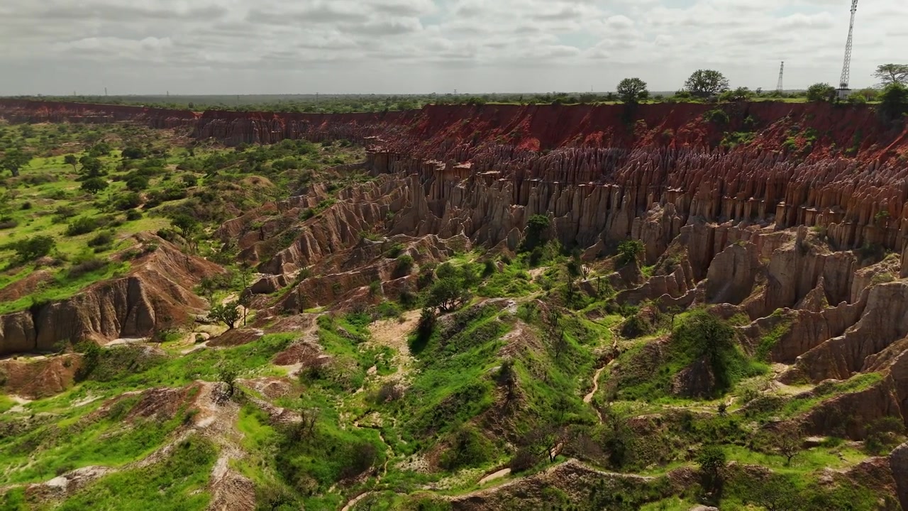 Panoramic aerial view of Miradouro da Lua featuring dramatic eroded rock formations, sharp clay spires, and striking red soil cliffs overlooking coastal landscape in Luanda Angola.