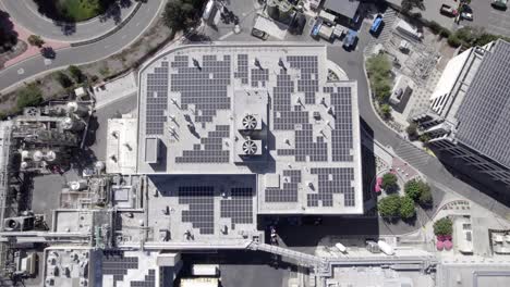 eco-friendly green energy solar panels on roof of large commercial ,building, top down aerial view