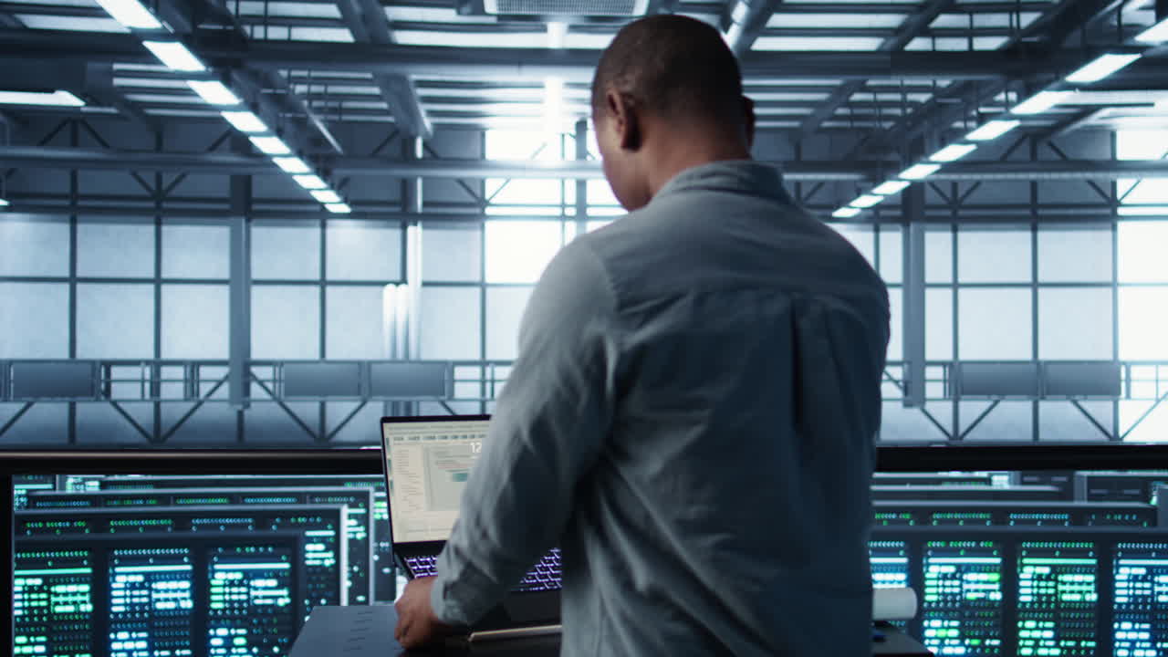 Man coding on data center, testing failover scenarios using notebook
