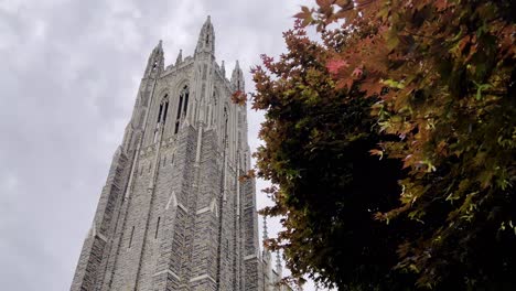 aerial-panning-duke-chapel-in-durham-nc,-north-carolina-through-japanese-maple-tree