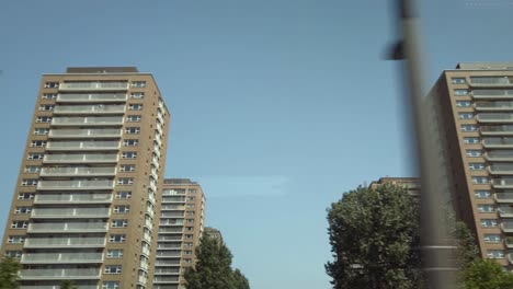 identical high-rise apartment buildings, shot from a riding bus