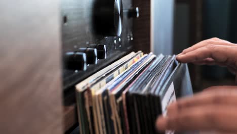 close up man hands browsing vintage vinyl records at home