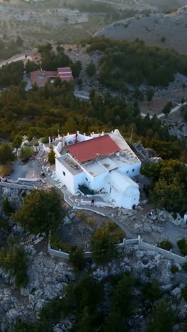 Vertical drone shot circling the Holy Monastery of Virgin Mary Tsambika in Rhodes