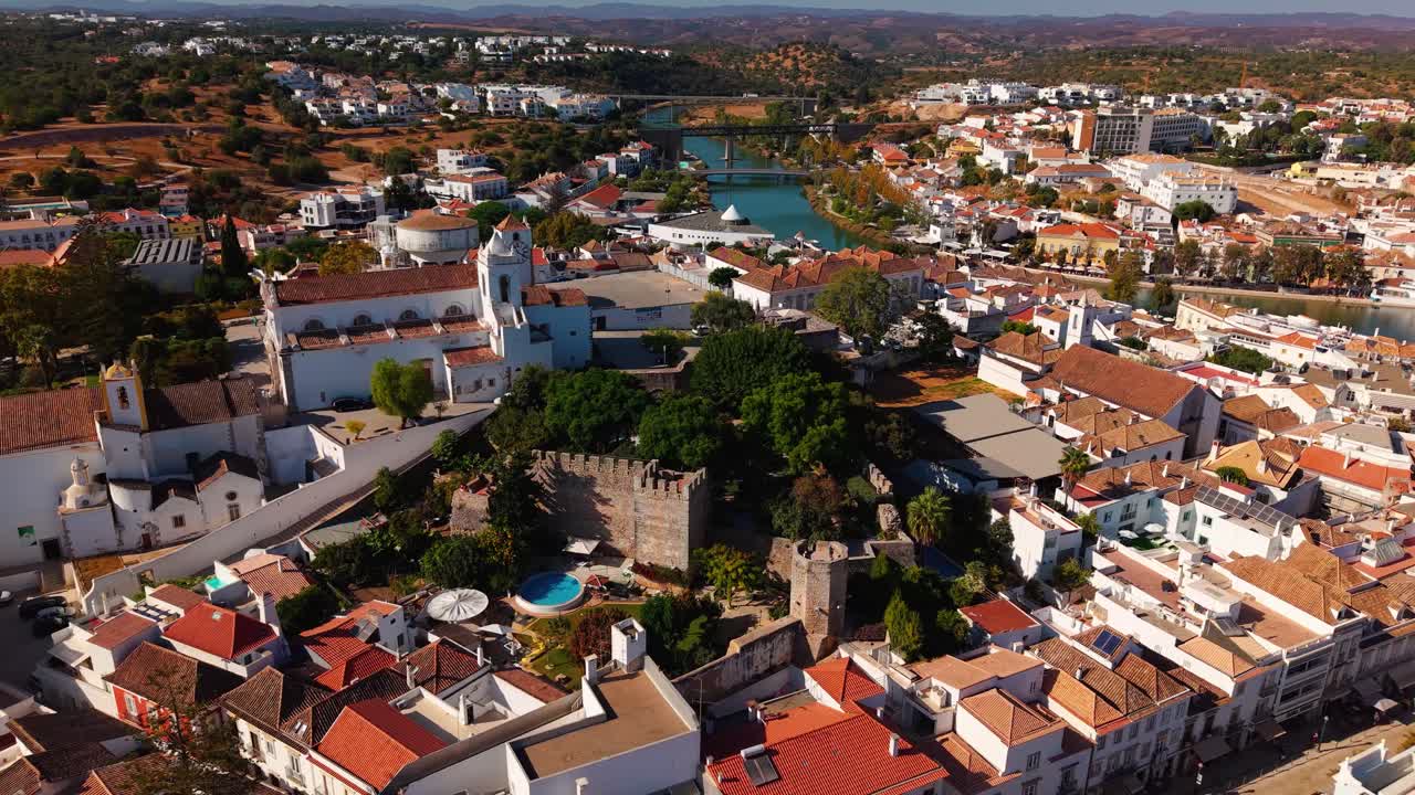 Aerial shot around Tavira castle, church and clock tower on a sunny day, Algarve region, Portugal