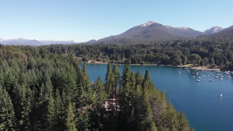 antena ascendente revela manzano resort en medio de bosque, lago y montañas, villa la angostura