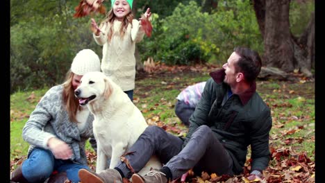 family with their dog on autumns day in park