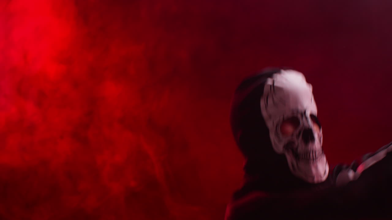 Studio Shot Of Child Dressed Up In Skeleton Costume Trick Or Treating At Halloween Dancing In Front Of Red Smoke Background Lighting 1