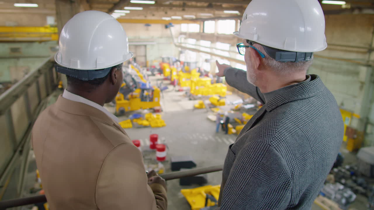 Ingegneri di diverse etnie che discutono di lavoro in fabbrica
