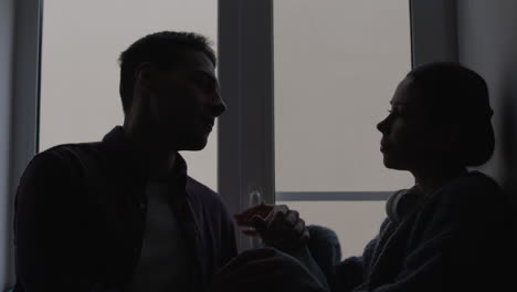 couple kissing by the window