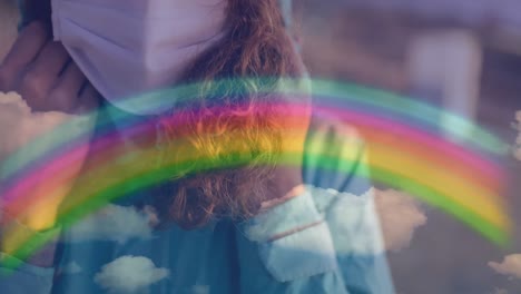 arco iris y cielo azul contra una mujer con una máscara facial