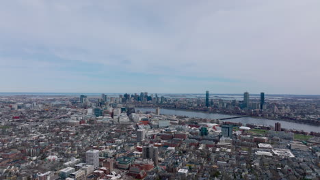 Fly-above-large-city.-Wide-river-flowing-through-metropolis.-Evening-aerial-shot-of-town-development.-Boston,-USA