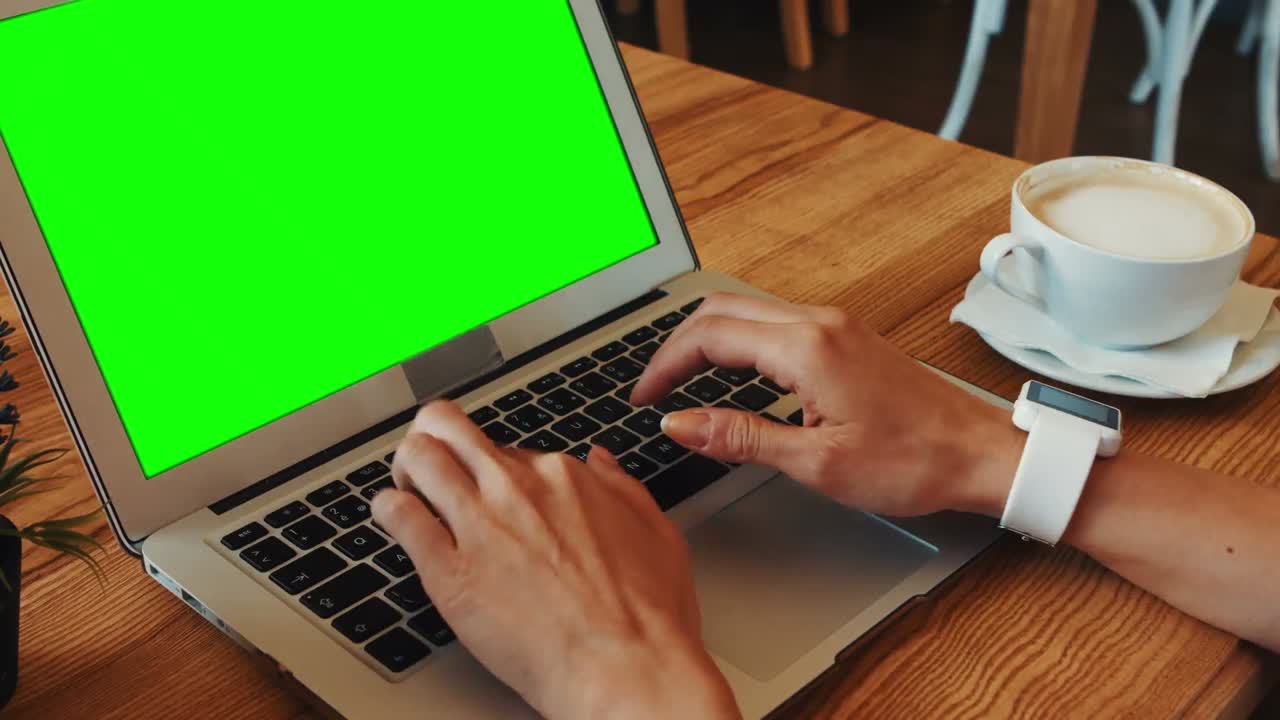 Woman using laptop while having coffee