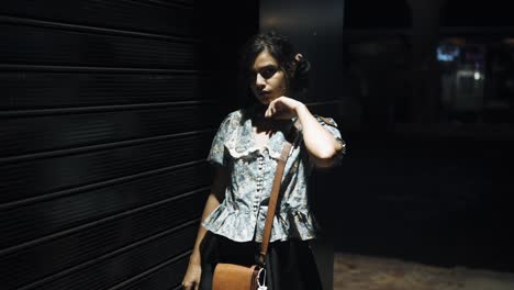 una chica con ojos profundos está posando durante la noche al aire libre y se da la vuelta