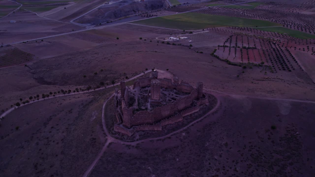 Forladte slotsruiner ved solopgang i Almonacid de Toledo