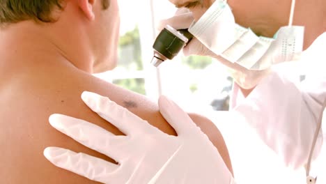 doctor checking a mole on patient