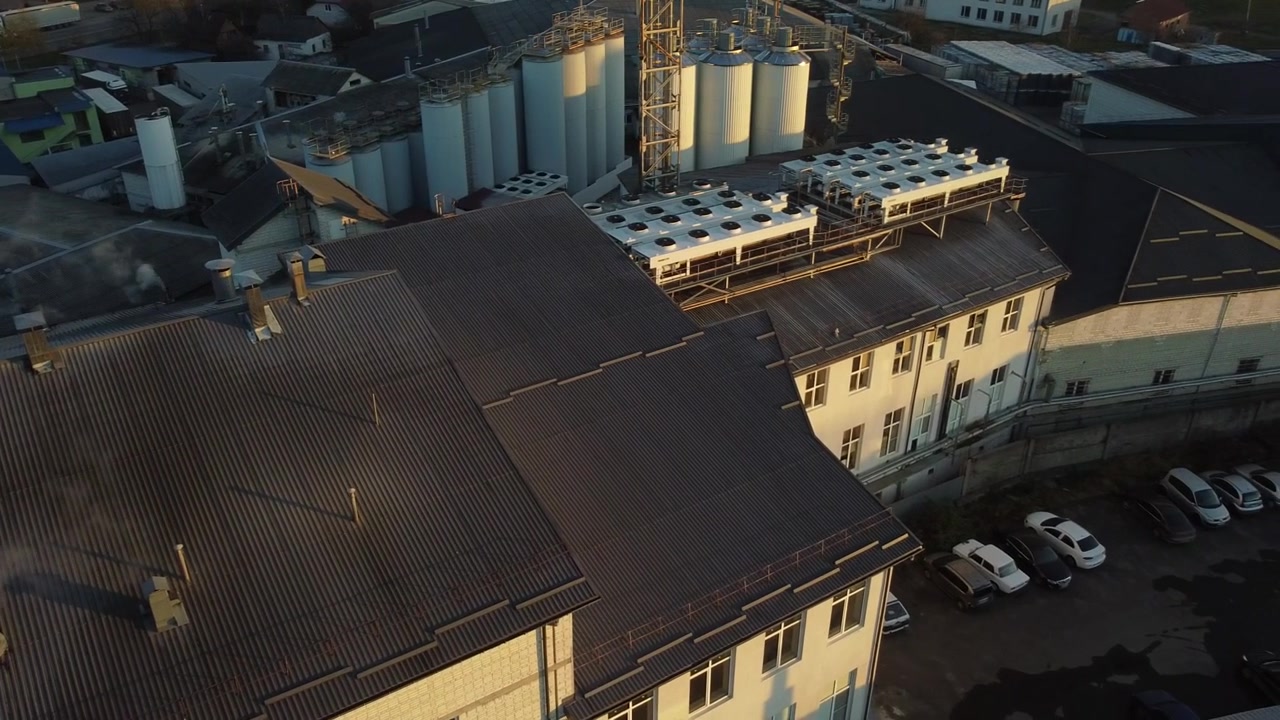 Vista aérea de un dron volando sobre la planta de producción de cerveza, varias filas de tanques