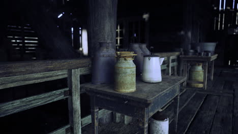 vintage milk cans and jars lined on wooden tables in a rustic barn setting
