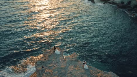 Multiple-couples-getting-married-on-the-edge-of-a-cliff-during-sunset