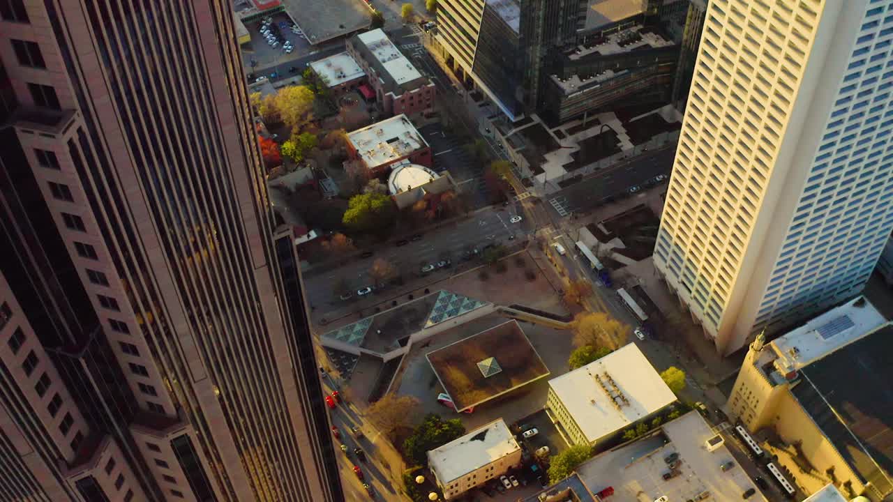 Filmagens aéreas de drone descendo lentamente ao lado do arranha-céu Bank of America no centro de Atlanta, Geórgia, revelando o tráfego abaixo durante o pôr do sol